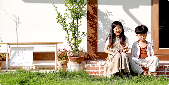 전소라·이차호님의 딸과 아들이 집 앞 턱에 앉아 있는 모습